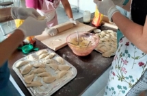 Kobiety nadziewaja pierogi farszem.